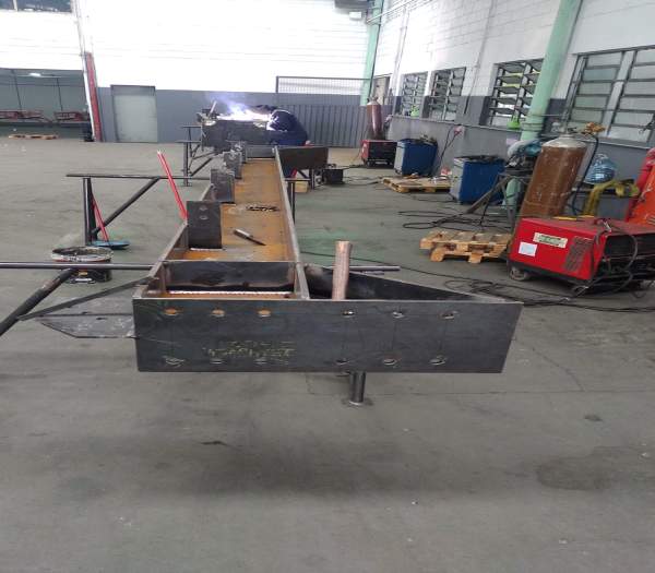 Montagem e soldagem de viga metálica reforçada para aplicação estrutural, em linha de produção na MetalPinda.
