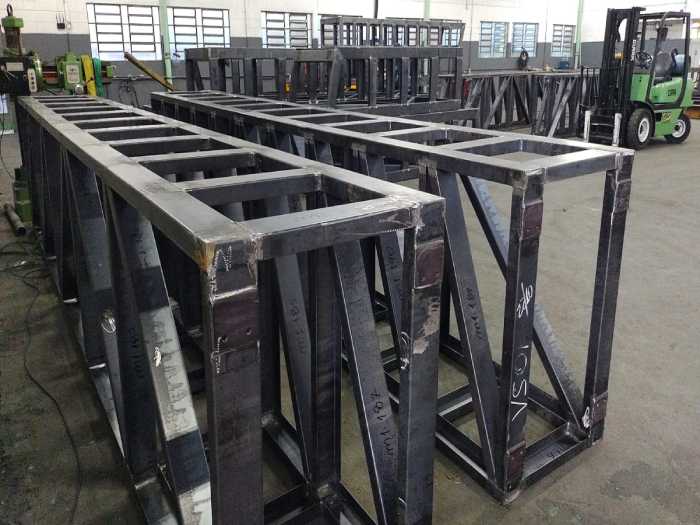 Estruturas metálicas finalizadas e organizadas para transporte, destinadas à obra de silo para moega, dentro da fábrica da MetalPinda.